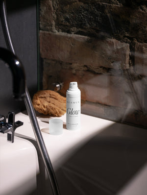 Glow bottle by a basin against a stone wall