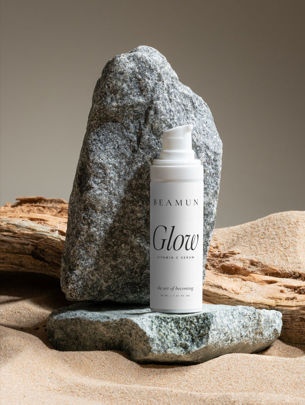 Glow bottle on sand beside granite and driftwood